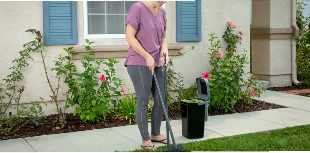 Woman cleaning pet waste in a front yard