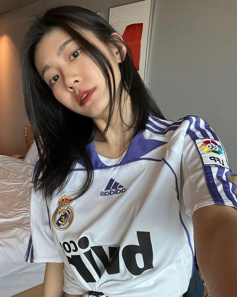 Selfie gái xinh với áo bóng đá màu trắng Real Madrid nổi bật trong căn phòng ấm cúng